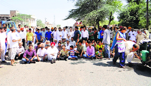 Protesters block the Kotkapura-Muktsar road on Monday. 