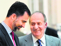 Spanish King Juan Carlos (R) talks to his son Crown Prince Felipe at El Pardo Palace im Madrid in this Feb 28, 2011 