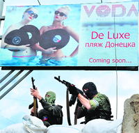 Pro-Russian armed militants stand guard at a barricade and check-point in Donetsk on Monday.