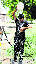 BEATING THE HEAT: A labourer tries to combat the heat at a hand pump in Model Town, Bathinda, on Tuesday