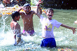 Children enjoy in a river to beat the heat in New Delhi on Tuesday