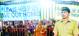 A policeman stands in front of a gate blocked by residents of Mumbai's Campa Cola housing colony. 