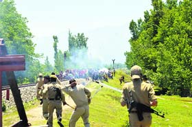 Police personnel fire teargas shells to disperse protesters at Sadoora village in Kulgam district on Tuesday