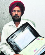 Ex-serviceman Tirath Singh shows his documents in Jalandhar