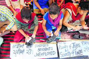 Students of Fishery College polish shoes during protest in Ludhiana.