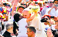 Pope Francis is greeted by a girl as he arrives to lead his weekly general audience in Vatican on Wednesday