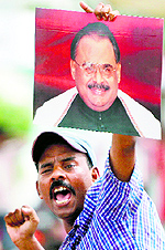 A supporter of Pakistans MQM holds a poster of Altaf Hussain to show solidarity with their leader, in Karachi on Wednesday