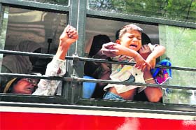 A child accompanying his mother during the protest cries in a police van