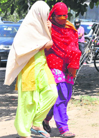 Girls cover their faces to escape heat in Chandigarh. 