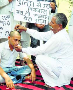 A social activist gets his head shaved to protest police inaction in Gharaunda on Thursday.