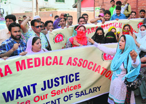 Members of the state National Rural Health Mission Paramedical Association hold a protest against the government for failing to regularise their service in Srinagar on Thursday.