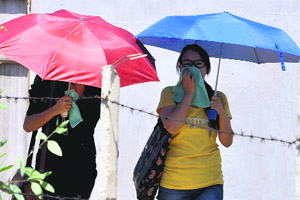 Girls protect themselves from the scorching sun with umbrellas in Jammu on Thursday.