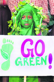 A child dressed up as a tree gives the message of protecting the green cover on World Environment Day in Jalandhar on Thursday