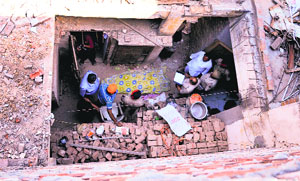Police officials inspect the spot where the labourer died at the Taj Gunj area on Thursday.