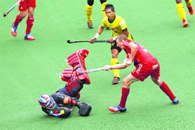 Malaysias goalkeeper Kumar Subramiam and Razie Abd Rahim (C) vie with Englands Tom Carson on Thursday