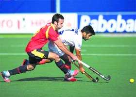 A Spanish player tries to catch up with an Indian forward during their contest in The Hague on Thursday