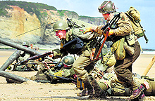 History enthusiasts wearing World War II US military uniforms re-enact a D-Day landing on Omaha Beach in Vierville sur Mer, on the coast of Normandy, on Thursday