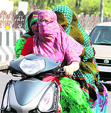 Girls cover their faces during the hot weather in Bathinda on Friday. Photo: Vijay Kumar