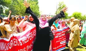Anganwari workers and helpers hold a protest, seeking a hike in monthly salary and regularisation of their services in Srinagar on Friday.