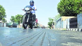 Intense heat melts asphalt on a busy road in Jammu on Friday.