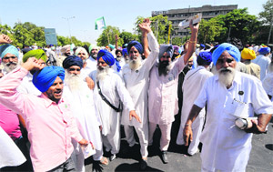 Members of the Bharatiya Kisan Union (Rajewal) block traffic in support of their demands in front of Kisan Bhawan in Sector 35, Chandigarh, on Friday.