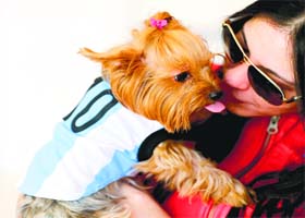A woman pets her dog, dressed in the Argentine colours, inside a pet clothing store in Buenos Aires