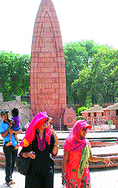 Visitors to Jallianwala Bagh protect themselves from the sun on a hot summer afternoon in Amritsar on Saturday