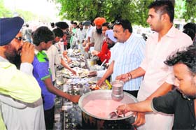 Volunteers offer sweet water during a chhabeel organised by the Car Bazar market to mark the martyrdom of Guru Arjan Dev in Bathinda on Saturday