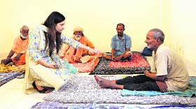 Additional Deputy Commissioner (Development) Isha Kalia interacts with a beggar at the shelter home on Hambran Road in Ludhiana on Saturday.
