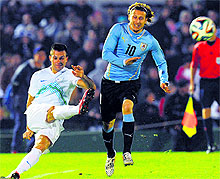 Uruguays forward Diego Forlan (R) vies for the ball with Slovenias Samerdeic Miral during a friendly match