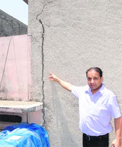 Resident Salil Mahajan shows the cracks in the walls of his house in Amritsar.