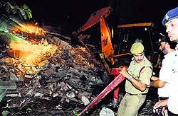 A JCB machine removes debris of the collapsed building