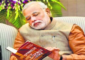PM Narendra Modi reads a book Getting India Back on Track  An Action Agenda for Reform at a function in New Delhi on Sunday