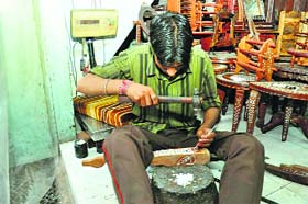 An artisan gives final shape to a carving
