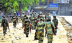 CRPF personnel patrol curfew-bound Tauru village in Mewat on Monday