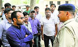 A policeman talks to construction company staff at Kalpana Chawla Government College in Karnal on Monday