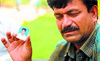 Banoth Shekhar Naik, father of missing student B Rambabu Naik, holds a photograph of his son in Hyderabad on Monday