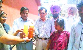 Residents of Industrial Estate show bottles of dirty water