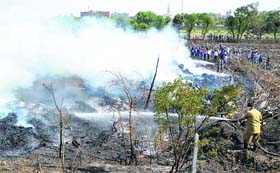 A firefighter douses the flames after a fire broke out at a godown in Ludhiana on Monday