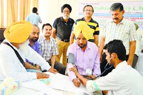 A doctor examines a resident during a free medical camp organised by the Ludhiana City Club at Sukhdev Singh Bhawan, PAU