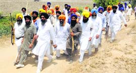 Members of the SGPC task force armed with weapons proceed towards Bhai Rupa village in Bathinda on Monday.