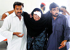 A woman wounded in a suicide attack at a hotel in Taftan, located near Iranian border, is helped by her relatives at a hospital in Quetta on Monday. 