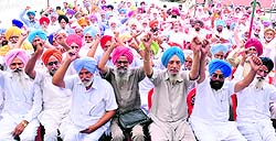 Members of the PRTC Retired Workers Bhaichara Manch shout slogans inside the bus stand in Bathinda on Monday