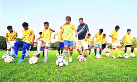 Football coach Harjinder Singh demonstrates skills to budding players of the Chandigarh Football Academy at Sector 42, Chandigarh, on Tuesday