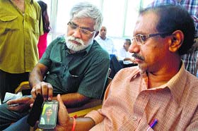 Krishna Reddy shows the picture of his missing daughter in Mandi on Tuesday.