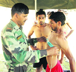 An Armyman measures the chest of a youth during a recruitment rally in Jalandhar on Tuesday.