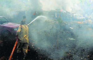A firefighter douses the flames at the vehicle compound of the Kotwali police station in Ludhiana on Tuesday.