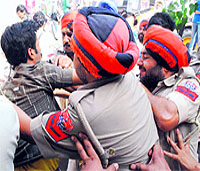 Policemen detain devotees who were trying to resist the demolition.