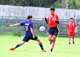 Players vie for the ball during the district football league at Pavilion Ground in Dehradun on Wednesday