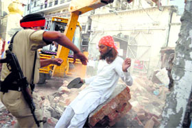 A devotee resists the demolition of a temple in Amritsar on Wednesday. 